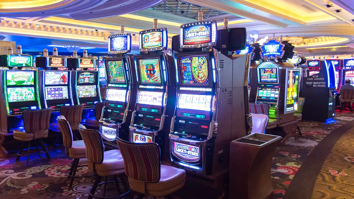 Row of video slot machines with chairs on a casino floor
